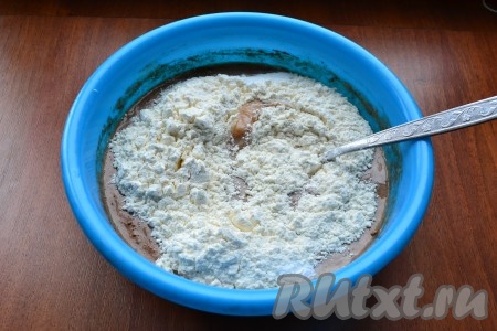 Перемешать массу до однородности, добавить разрыхлитель и половину муки, перемешать вилкой (или столовой ложкой).