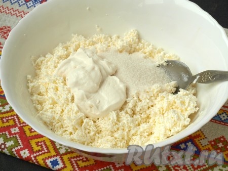 Добавить к творогу сметану и сахар. Смешать массу до однородности.
