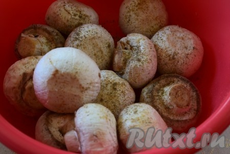 Кладем шампиньоны в миску, добавляем специи и соль.
