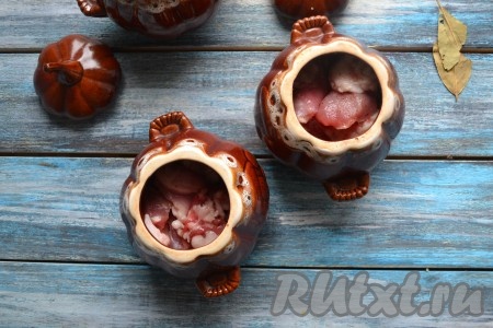 Кусочки кролика посолить и приправить молотым душистым перцем. Выложить его в горшочки.
