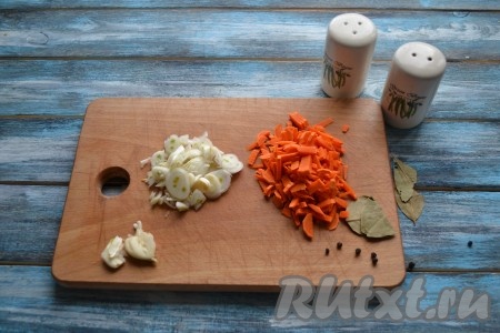 Очистить и вымыть овощи. Лук нарезать тонкими кольцами, морковь - соломкой, а чеснок прижать тыльной стороной ножа.
