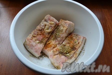 Нашпиговать каждый кусок сала кусочками чеснока, натереть солью и специями (у меня - красный острый молотый перец и хмели-сунели).
