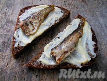 Затем на каждый кусок хлеба, смазанный майонезом, выложите по 1 крупной или по 2 мелкой рыбке.
