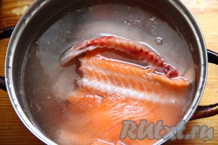 Рыбные обрезки семги заливаем водой (я готовила из хребта и головы), отправляем кастрюлю на огонь, после закипания уменьшаем огонь и варим около 30 минут на небольшом огне. По истечении времени достаем рыбу из бульона, отделяем от костей и откладываем в сторону.