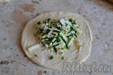 На столе, присыпанном мукой, каждую часть теста раскатать в лепешку толщиной около 0,5 см. В середину лепешек выложить брынзу с зеленью.