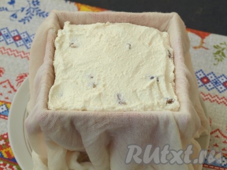 Влажной марлей выстелить пасочницу или сито, выложить туда творожную массу. Свободными концами марли прикрыть пасху, сверху поставить блюдце, а на него, в качестве груза, - банку с водой объёмом 500 мл. Убрать пасху вместе с грузом в холодильник на сутки, периодически сливать сыворотку.
