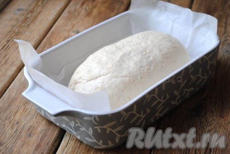 Тесто ещё раз обмять. Форму для выпечки застелить пергаментом или смазать растительным маслом, выложить в форму тесто. Накрыть форму полотенцем и дать заготовке расстояться около 30 минут.