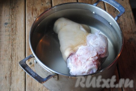 В глубокую кастрюлю выложить рульку и залить её полностью водой. Как только вода закипит, слить ее и залить мясо чистой водой. Опять поставить вариться. 