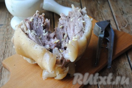 Чеснок очистить и пропустить через пресс. Свиную рульку обмазать солью, чёрным молотым перцем и чесночной кашицей. 