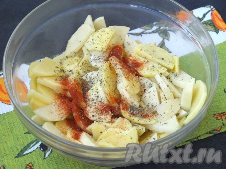 Картофель очистить, нарезать на достаточно тонкие ломтики, сложить в миску, добавить соль, приправить специями (в качестве специй я всыпала 1 чайную ложку паприки и сушёный базилик), перемешать. Влить к картошке подсолнечное масло, хорошо перемешать.