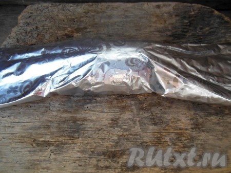 Скрутите фольгу рулетом так, чтобы картофелина оказалась внутри.