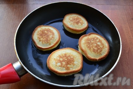 Жарить оладушки под прикрытой крышкой на небольшом огне до румяного цвета с двух сторон.
