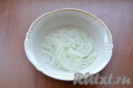 Репчатый лук нарезать тонкими полукольцами, залить кипятком на 10 минут, затем промыть лук холодной водой и отжать.
