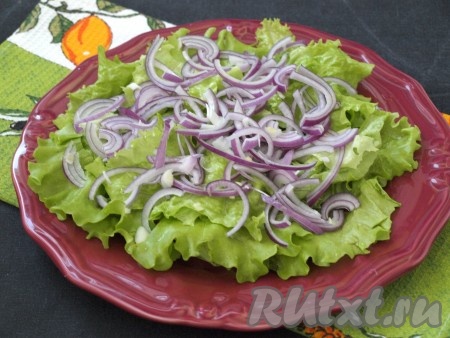 Листья салата вымыть, промокнуть салфетками для удаления влаги, порвать руками и выложить на тарелку. Тонко нарезать красный лук. Лук лучше взять небольшого размера, чтобы он не доминировал в салате. Выложить тонкие полукольца лука на листья салата.
