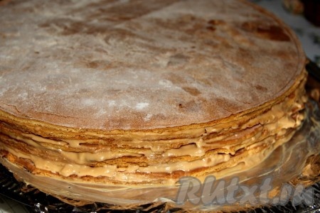 Смазываем коржи кремом, верхний корж медового торта смазываем кремом с желатином и посыпаем бока измельченными остатками от обрезания коржей.