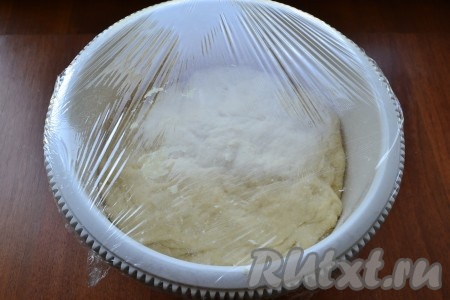 Опустить тесто рукой, снова накрыть пищевой пленкой и оставить еще на 50-60 минут.