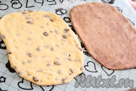 Подошедшее тесто хорошо обмять, а затем на столе, присыпанном мукой, или на силиконовом коврике раскатать в пласт. Получится два прямоугольника. Тесто не стоит раскатывать слишком тонко.

