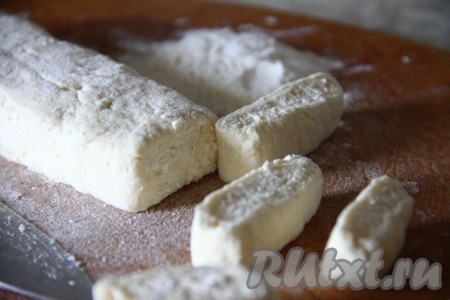 Тесто разделить на 2 части. На столе, присыпанном мукой, каждую часть теста раскатать и сформировать колбаску. Нарезать творожное тесто на порционные кусочки.
