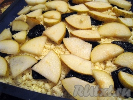 На творожное тесто выложить чернослив и нарезанные дольками груши.