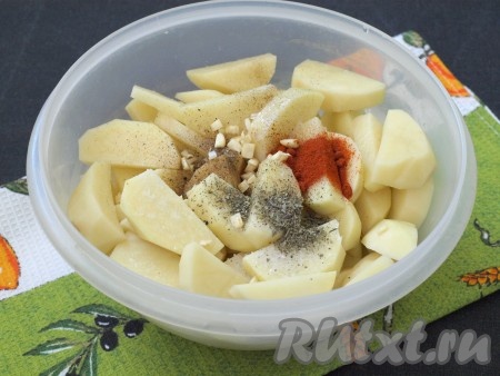 Нарезать ломтиками очищенный картофель, сложить в миску, добавить приправу, базилик, паприку, соль и измельчённый чеснок. Я чеснок нарезала кубиками, можно пропустить через пресс.
