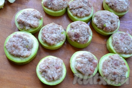 Наполнить отверстия кабачков фаршем так, чтобы он покрыл и верхнюю часть кружочков.