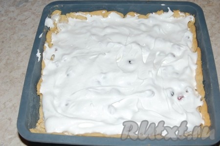 На корж выложить взбитые белки с клюквой. Сверху выложить отложенные взбитые белки (без ягод), это позволит сделать верх пирога более красивым.
