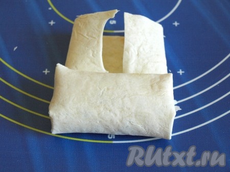 Подвернуть лаваш с двух сторон по бокам, а затем от края свернуть в трубочку.
