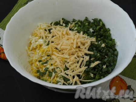Варёные яйца и твёрдый сыр натереть на тёрке. Соединить в миске сыр, яйца и зелёный лук, перемешать.
