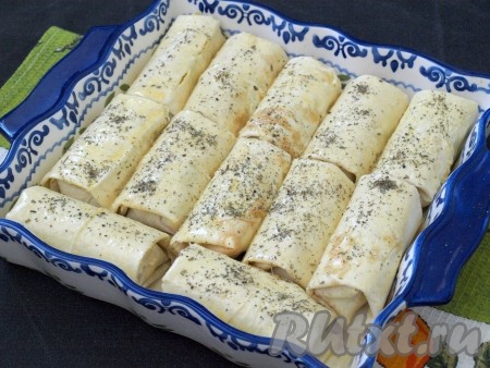 Форму для запекания смазать растительным маслом, выложить в неё пирожки. В мисочке взбить яйцо и смазать им все пирожки. По желанию можно посыпать сверху сухим базиликом или другими травками.
