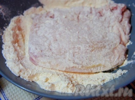 Обвалять отбитые свиные стейки в муке.