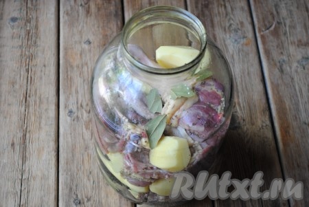 Картофель также приправить специями. В чистую сухую 3-литровую банку слоями выложить мясо с картошкой. Добавить лавровый лист и душистый перец.
