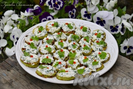 Получившуюся творожную смесь выложить поверх каждого обжаренного кружочка кабачка, украсить листочком зелени и выложить на блюдо.&nbsp;Дать закуске из жареных кабачков и творога настояться в течение минут 20 и подать к столу.&nbsp;Я дополнительно на каждый кружочек сверху для остроты добавила капельку кетчупа чили, но это по желанию.