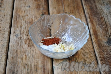 В небольшой мисочке соединить соль, молотую паприку и чёрный молотый перец, затем добавить выдавленный через пресс чеснок.&nbsp;
