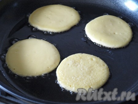 На плите разогреть сковороду с маслом. Столовой ложкой налить тесто, формируя оладьи.
