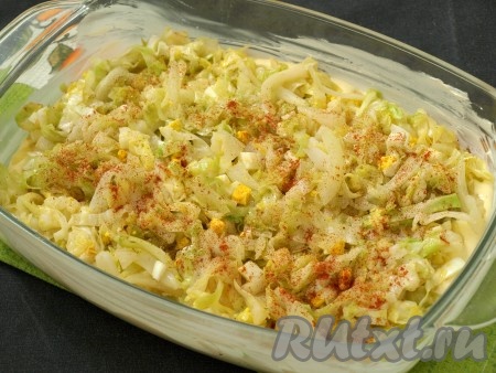 Смазать сливочным маслом форму для запекания, вылить половину творожной заливки. Сверху выложить капустную начинку, ещё немного посыпать красным перцем или смесью перцев.
