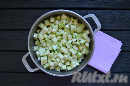 Если сковорода большая, можно продолжить приготовление в ней, если нет - необходимо переложить содержимое сковороды в казан или толстостенную кастрюлю. Кабачки вымыть (если кабачки молодые - их можно не очищать от шкурки и семян) и нарезать небольшими кубиками. Выложить нарезанные кабачки в казан к капусте, морковке и луку, накрыть крышкой, огонь снизить к минимуму и тушить 20 минут. За это время кабачки пустят сок и жидкости для тушения овощей будет достаточно. Если все же жидкости мало - влейте немного горячей кипяченой воды.
