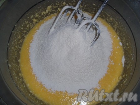 Муку, крахмал, разрыхлитель и соль просеять и всыпать в масляную массу, перемешать до однородного состояния. Тесто по консистенции будет напоминать густую сметану.