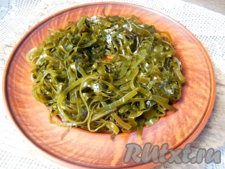 Салат можно выложить на одно блюдо или, как я, порционно на каждую тарелку, разделив все ингредиенты поровну. На блюдо (или на каждую тарелку) выложите морскую капусту, сделайте в ней углубление.