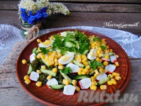 Поверх салата выложите дольки яиц, пару столовых ложек майонеза (у меня домашний майонез), украсьте листьями петрушки и розочкой из огурца. Сочный, вкусный салат из морской капусты с кукурузой и крабовыми палочками сразу подать на стол, ну а перемешать его можно уже после подачи.

