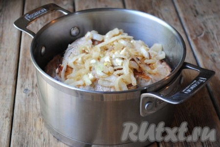 Затем к обжаренному луку всыпать муку, перемешать, обжарить лук с мукой ещё пару минут, не забывая иногда помешивать. Лук, обжаренный с мукой, выложить к мясу кролика. 