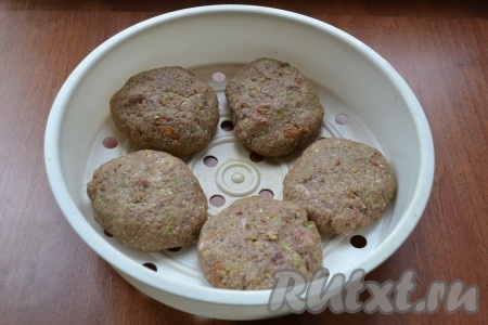 Затем добавить в фарш ложку муки, еще раз перемешать и сформировать небольшие котлеты. Чашу мультиварки для варки на пару чуть смазать растительным маслом и выложить в неё котлеты из говядины.
