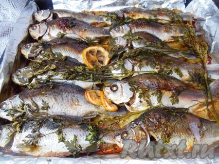 Противень поставьте в духовку, разогретую до 180 градусов, и запекайте картошку с карасями около 25-30 минут. Затем фольгу уберите и запекайте рыбу еще минут 10-15 (до румяного цвета).