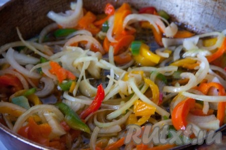 В сковороду с маслом, в котором мы жарили курицу, насыпать сахар и обжарить его, помешивая, до легкого карамельного цвета (на это уйдёт, примерно, 1-2 минуты). К получившейся карамели влить уксус и перемешать. Чеснок и лук очистить. Из перца удалить семенной короб. Чеснок нарезать мелко, перец и лук нарезать соломкой и отправить в сковороду с обжаренным сахаром и уксусом, перемешать и тушить овощи, примерно, 5 минут, периодически помешивая.