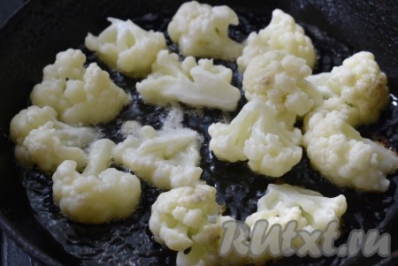 Выложить цветную капусту в кляре в разогретую с растительным маслом сковороду и обжарить на среднем огне до румяной корочки со всех сторон.