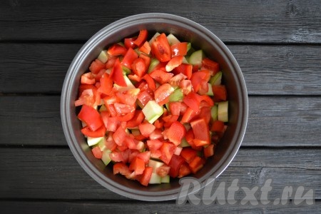 Из болгарского перца удалить семена и плодоножку. Сразу после кабачков в чашу мультиварки выложить нарезанные кубиками помидоры и перец. 
