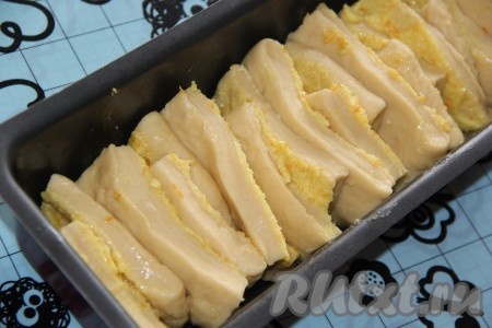 Для пирога "Гармошка" нужно использовать прямоугольную форму для выпечки кекса или хлеба. Смазать форму растительным маслом, выложить тесто в форму. Каждый прямоугольник теста, смазанный начинкой, слегка растянуть и сложить его пополам начинкой внутрь. Сгибом вниз выложить прямоугольники в форму один за другим, как на фото.