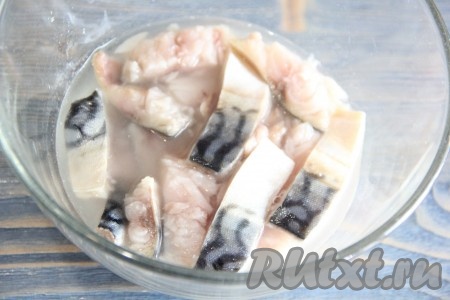 Залить кусочки рыбы уксусом, накрыть блюдцем, поставить сверху груз и оставить скумбрию в уксусе на 30 минут.