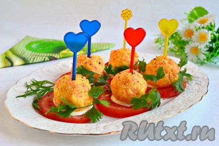 На помидоры выложить подготовленные перепелиные яйца в сыре, поперчить немного, украсить зеленью и вставить шпажки.