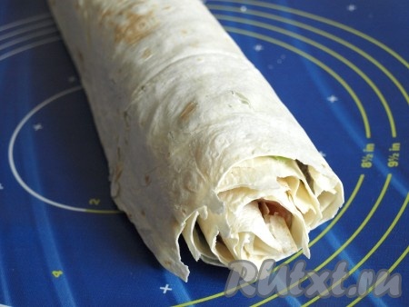 Начиная от края, свернуть лаваш в рулет. Завернуть в пищевую плёнку и отправить на пару часов в холодильник.

