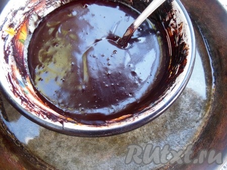 Можно массу поставить на медленный огонь и варить глазурь, помешивая, в течение минут 2-3 (до однородности), минус такого способа приготовления глазури в том, что нагревается она неравномерно и может пригореть. Я предлагаю более простой вариант: поставьте сковороду на небольшой огонь, налейте в неё воду и сразу поставьте в сковороду железную миску со смесью какао, сахара и сметаны. При нагревании воды будет нагреваться и глазурь. Все время помешивая, варите, примерно, 2-3 минуты, до получения однородной массы (сахар при этом должен полностью растаять). При таком способе глазурь равномерно прогревается и не пригорает.